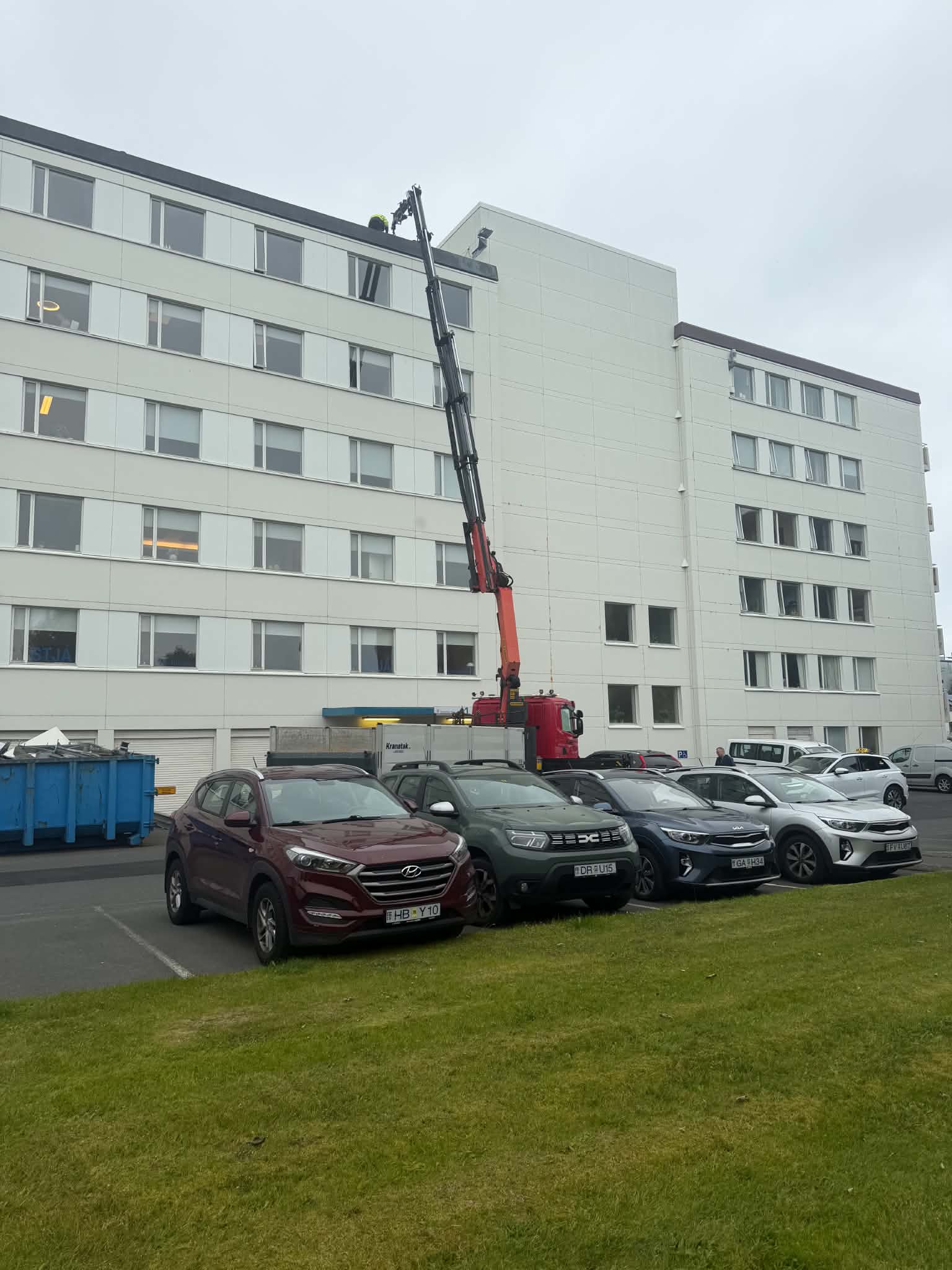 Kranatak krani við fjölbýlishús, kraninn teygður til hæðar
